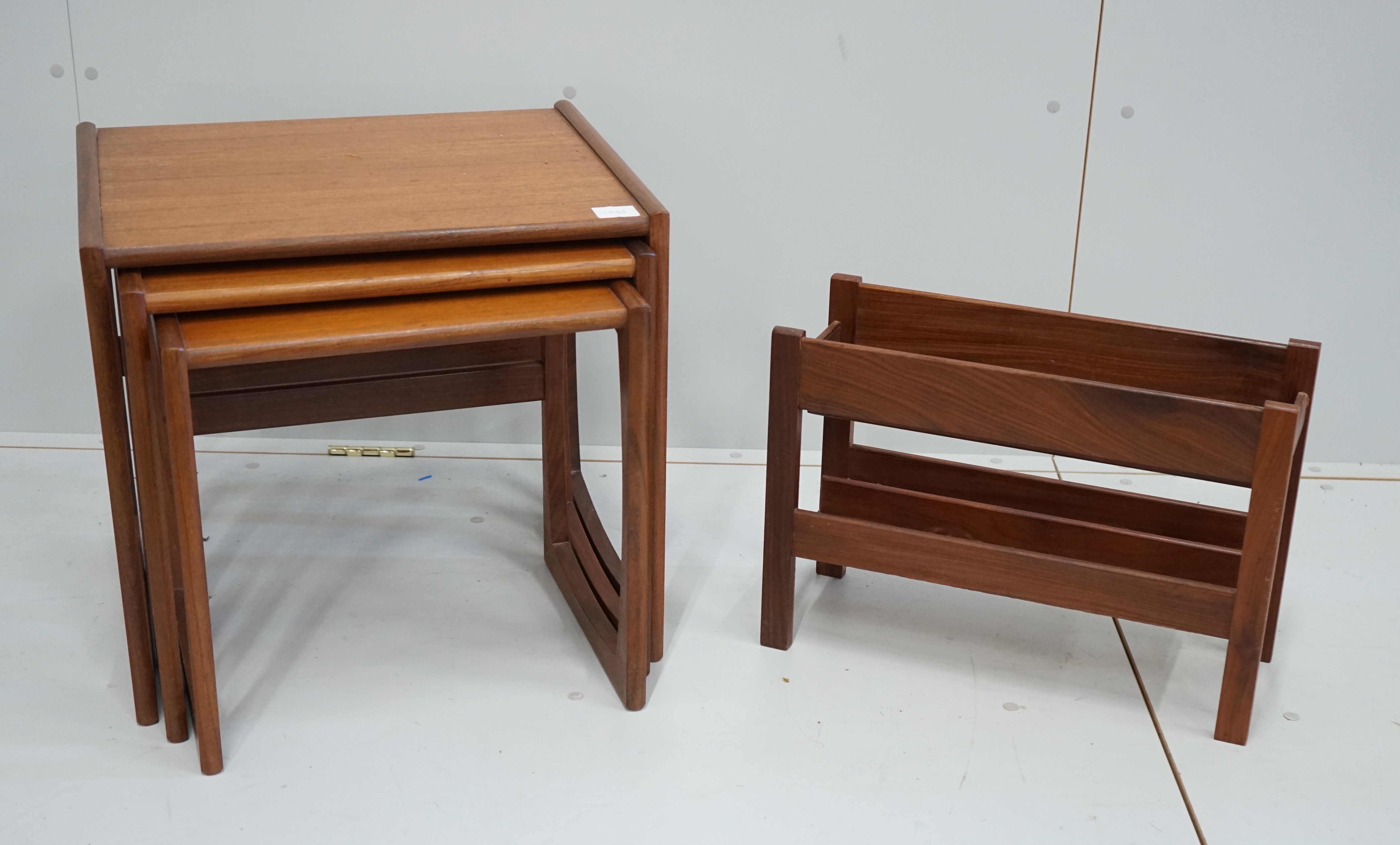 A nest of three G Plan teak tables, width 53cm, depth 43cm, height 49cm together with a two division Canterbury